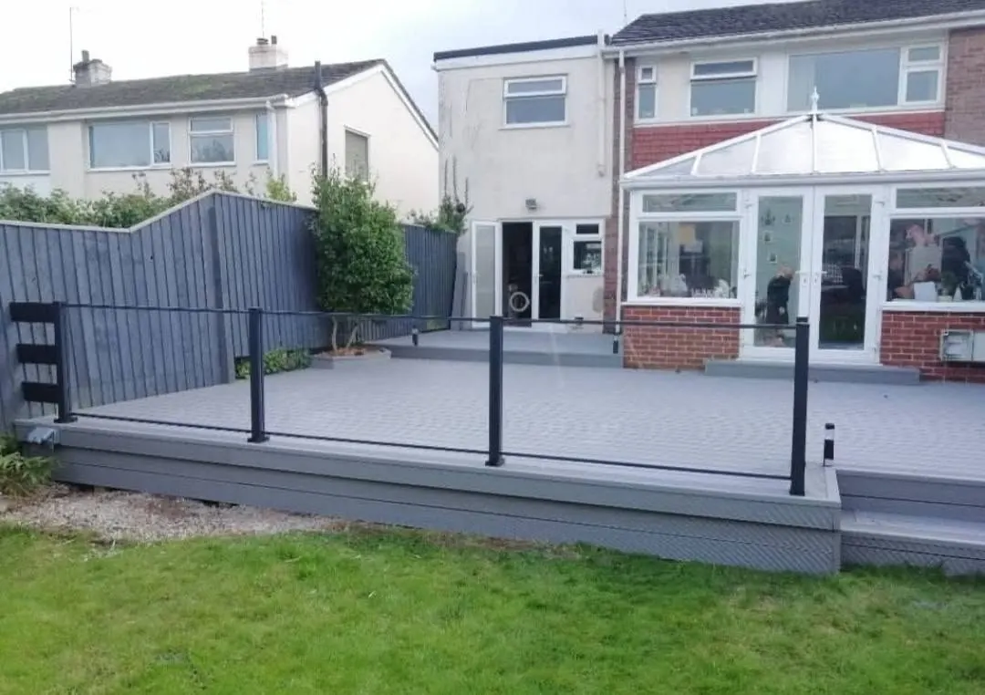Composite deck with a glass balustrade beside a conservatory, a real Crews Carpentry job
